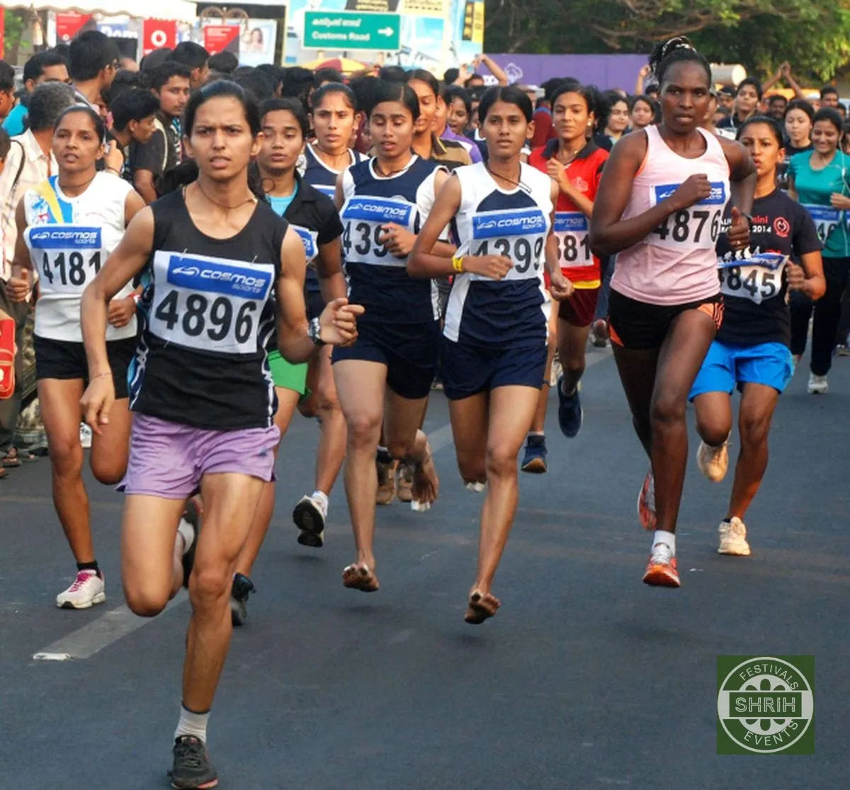 Runners wearing race bibs on a city road during a morning marathon